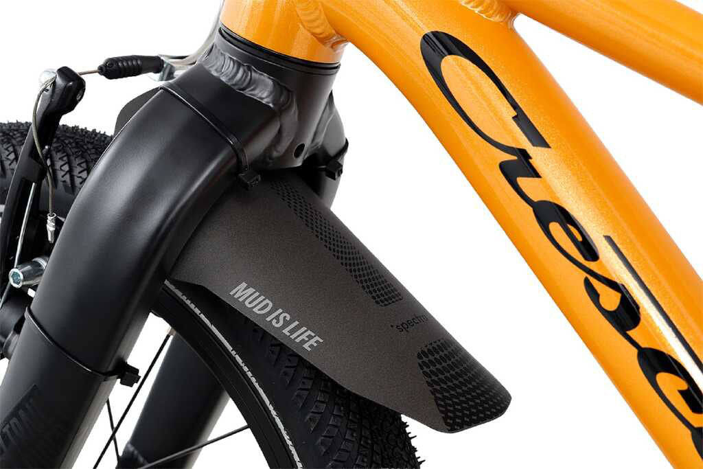 Oranssi lasten 16" jalkajarrullinen polkupyörä. Pyörässä on vakiovarusteina seisontatuki ja lokasuoja edessä. Lähikuva lokasuojasta.