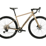 Kulta-beige 12-vaihteinen, alumiinirunkoinen ja hiilikuituihaarukkainen gravel-pyörä. Kuvattu sivulta.