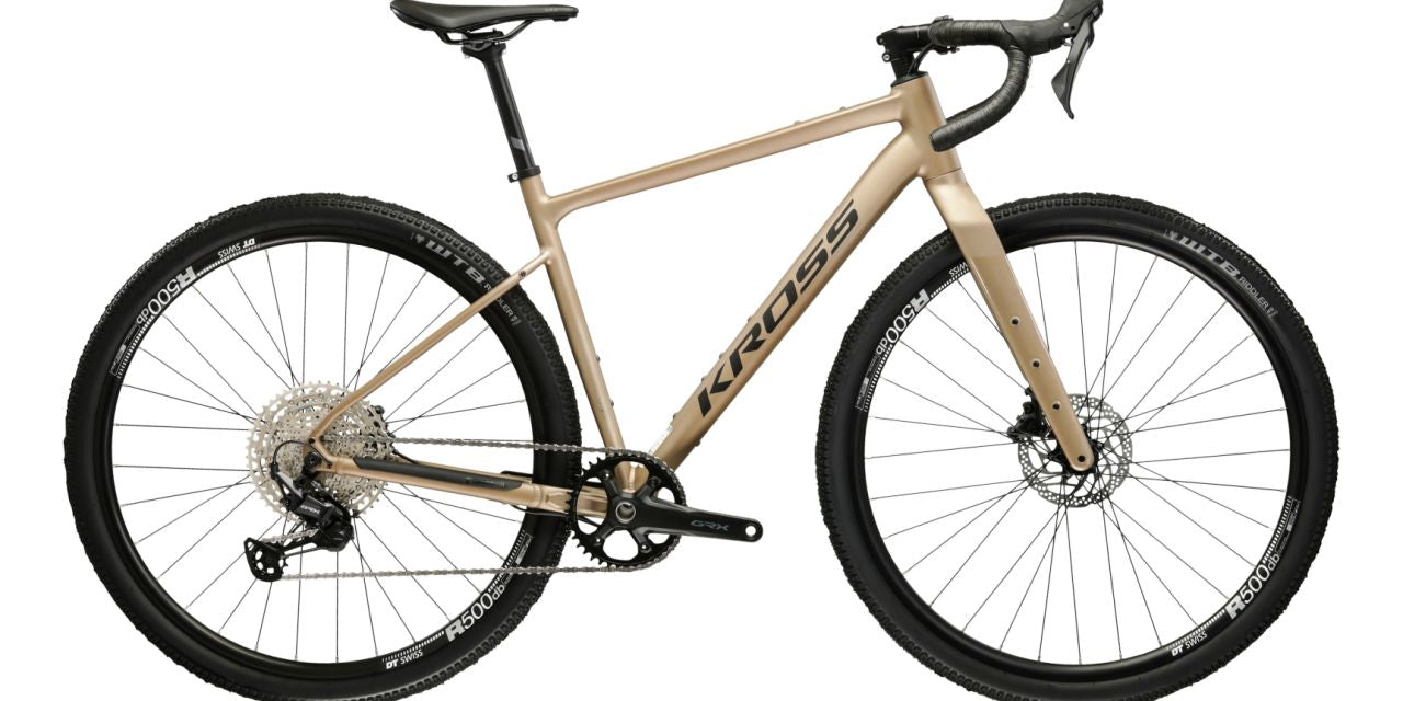Kulta-beige 12-vaihteinen, alumiinirunkoinen ja hiilikuituihaarukkainen gravel-pyörä. Kuvattu sivulta.